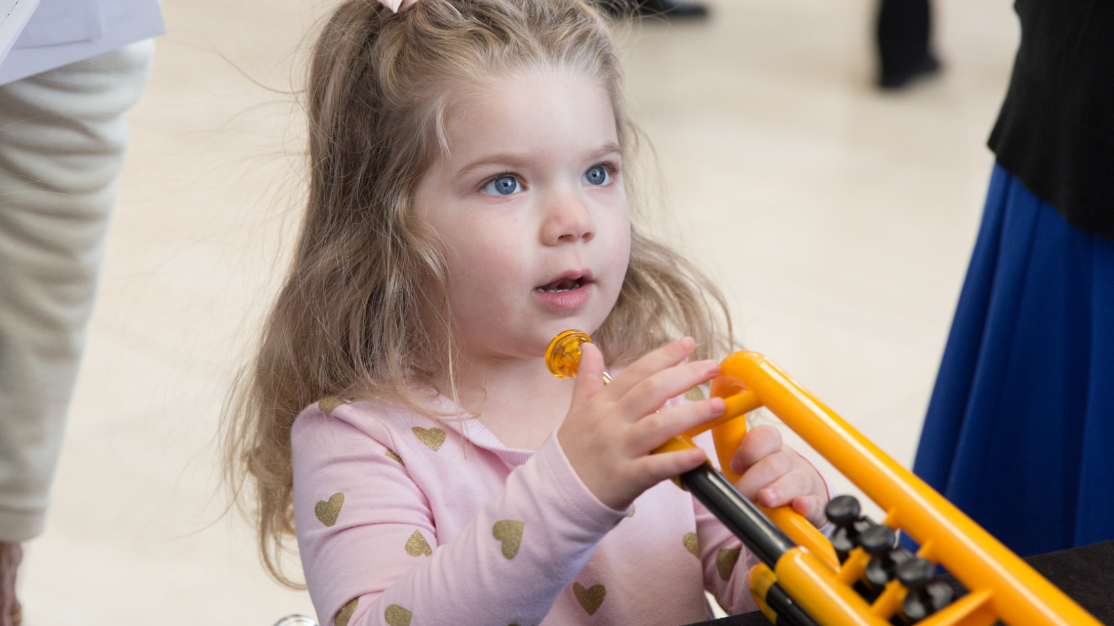 Una niña con una trompeta de juguete