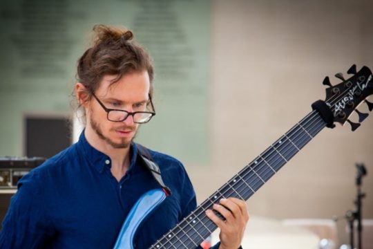 Robert Trusko tocando la guitarra durante una muestra del Distrito de las Artes en el Meyerson