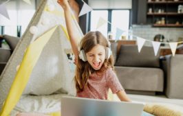 little girl playing an online game and winning in her house