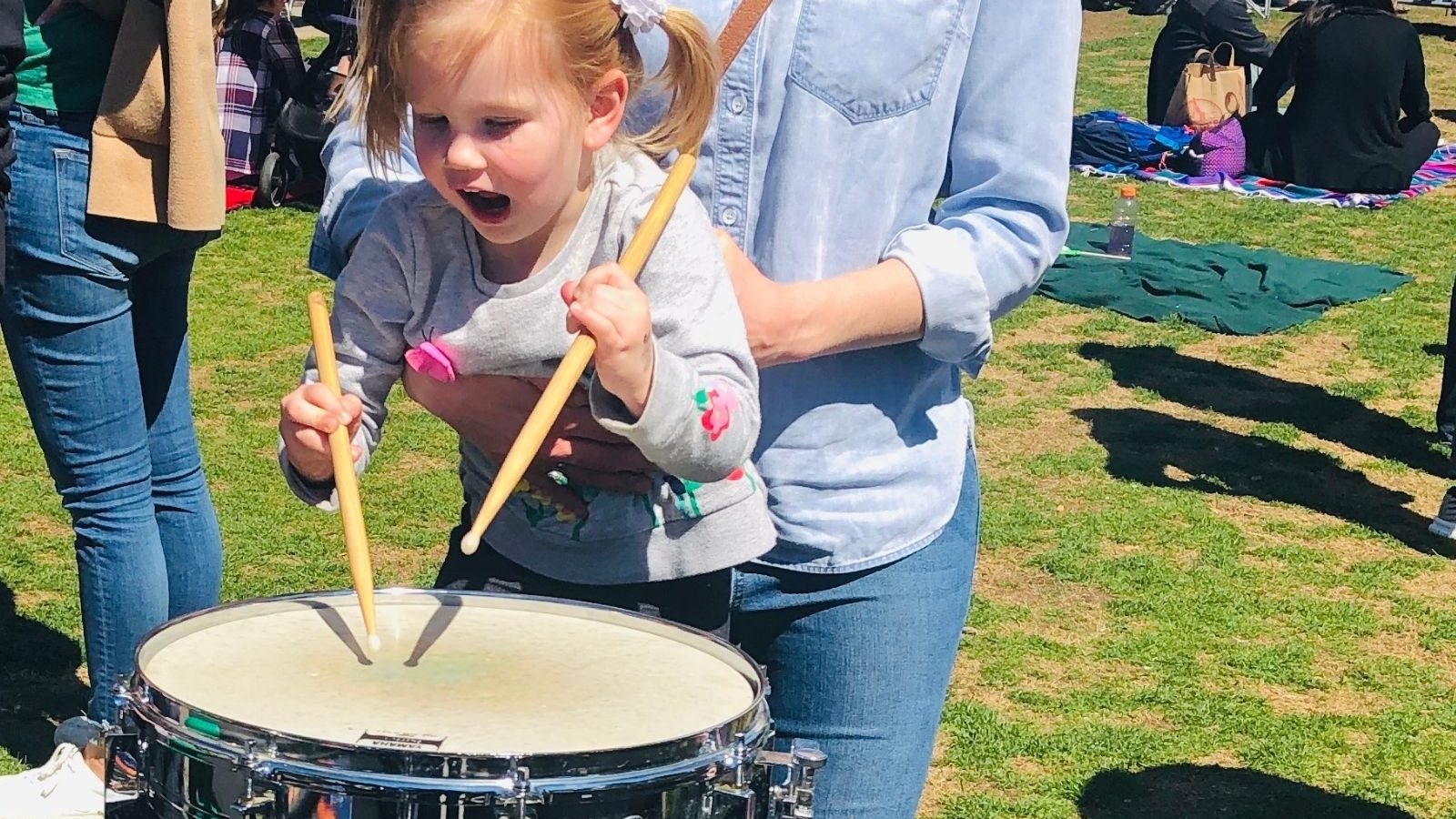 Little girl playing a drum at a DSO Parks Concert