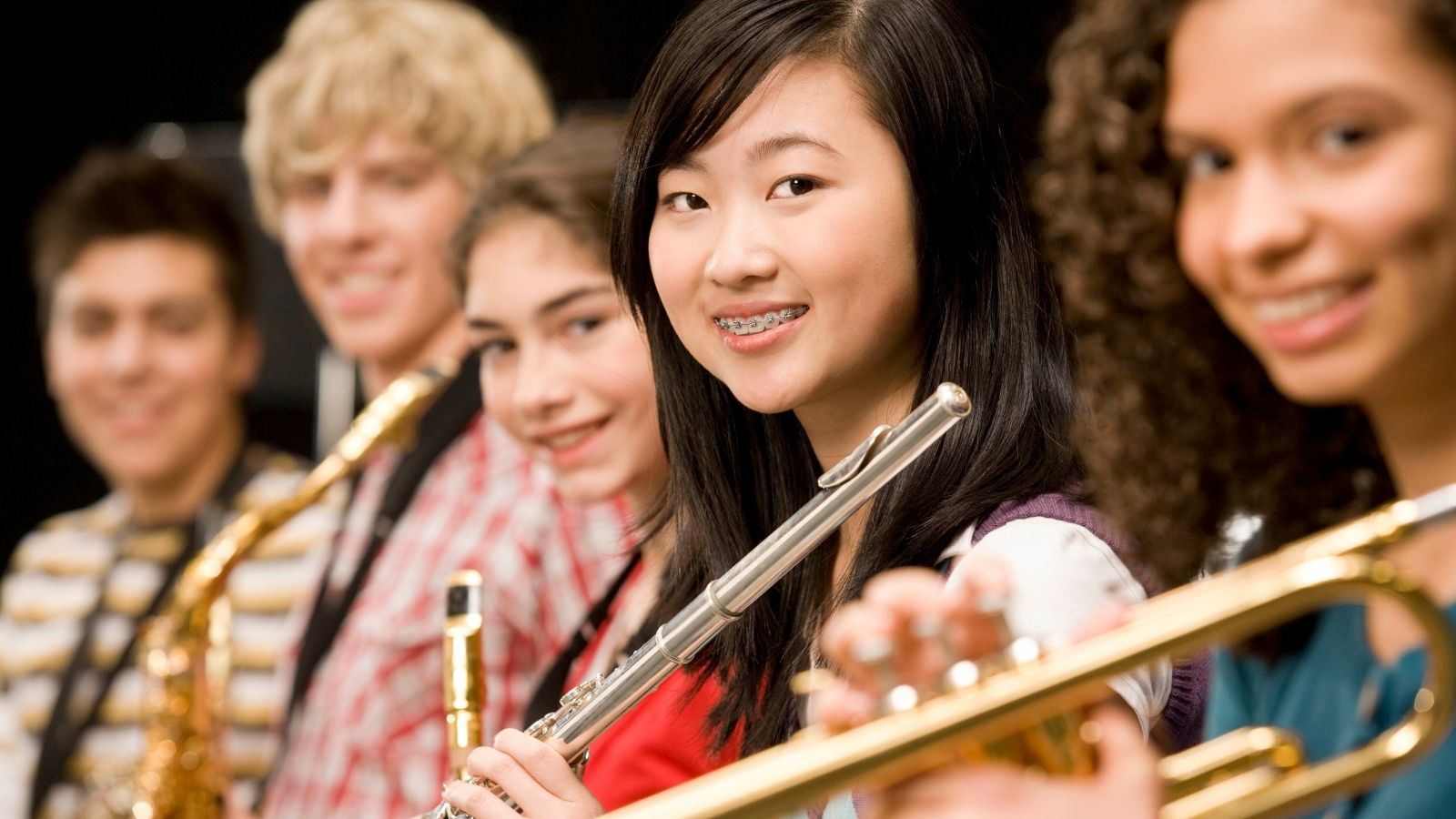 Cinco estudiantes en una clase de música de la escuela secundaria