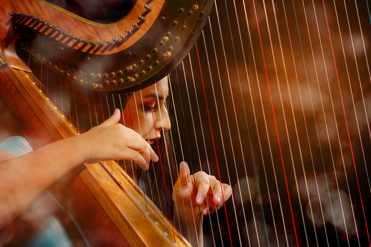 woman playing harp in an orchestra